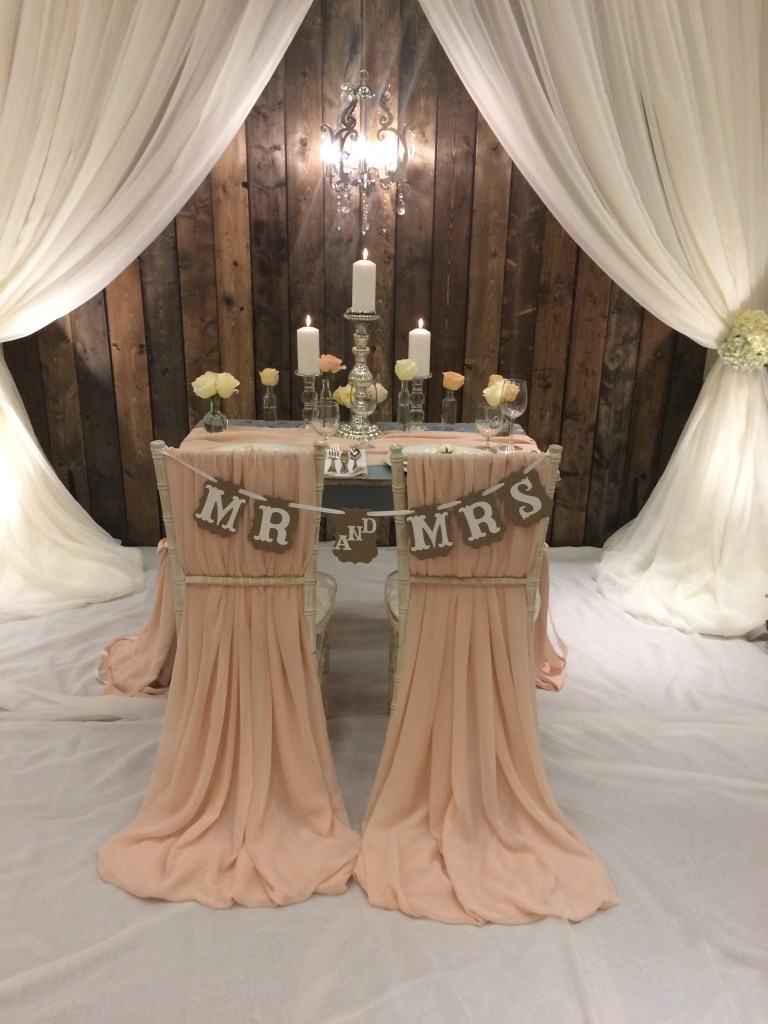 Our Barnwood Chandelier Backdrop Includes Voile Fabric. Pictured here is our 10 Ft. Version. Our 20 Ft. Version has 3 sections of Barnwood Framed by Fabric